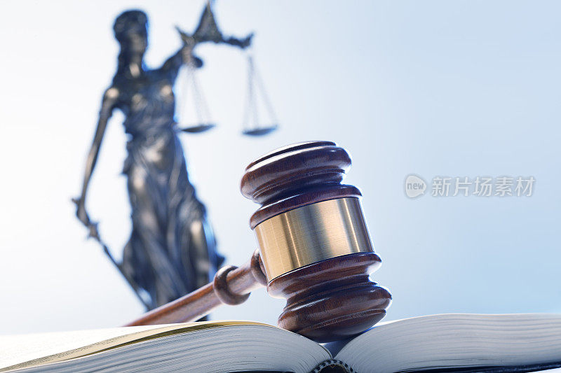 小木槌On Open Law Book With Lady Justice In The Background